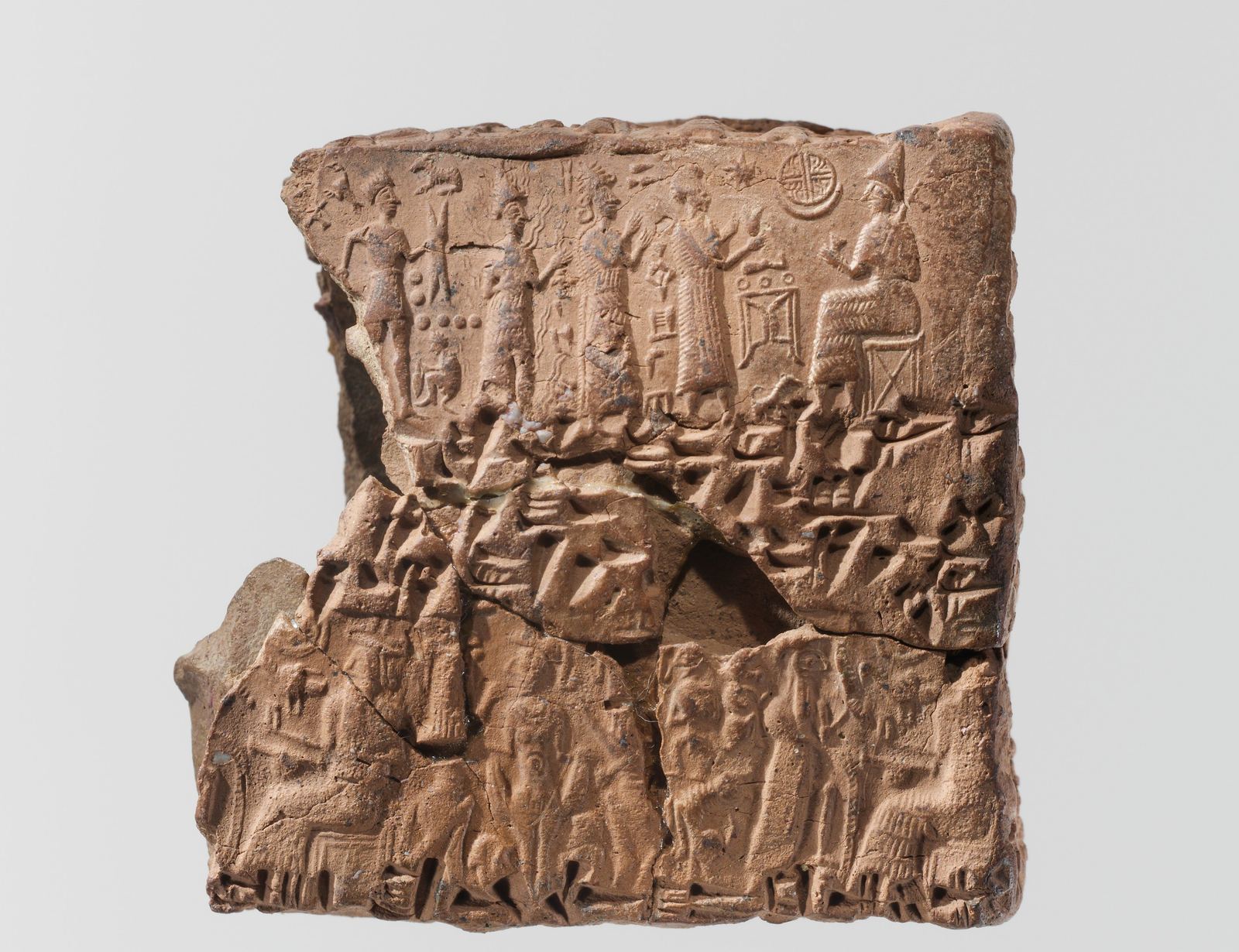 Cuneiform tablet case carrying rolled cylinder-seal impressions above the contract text in cuneiform